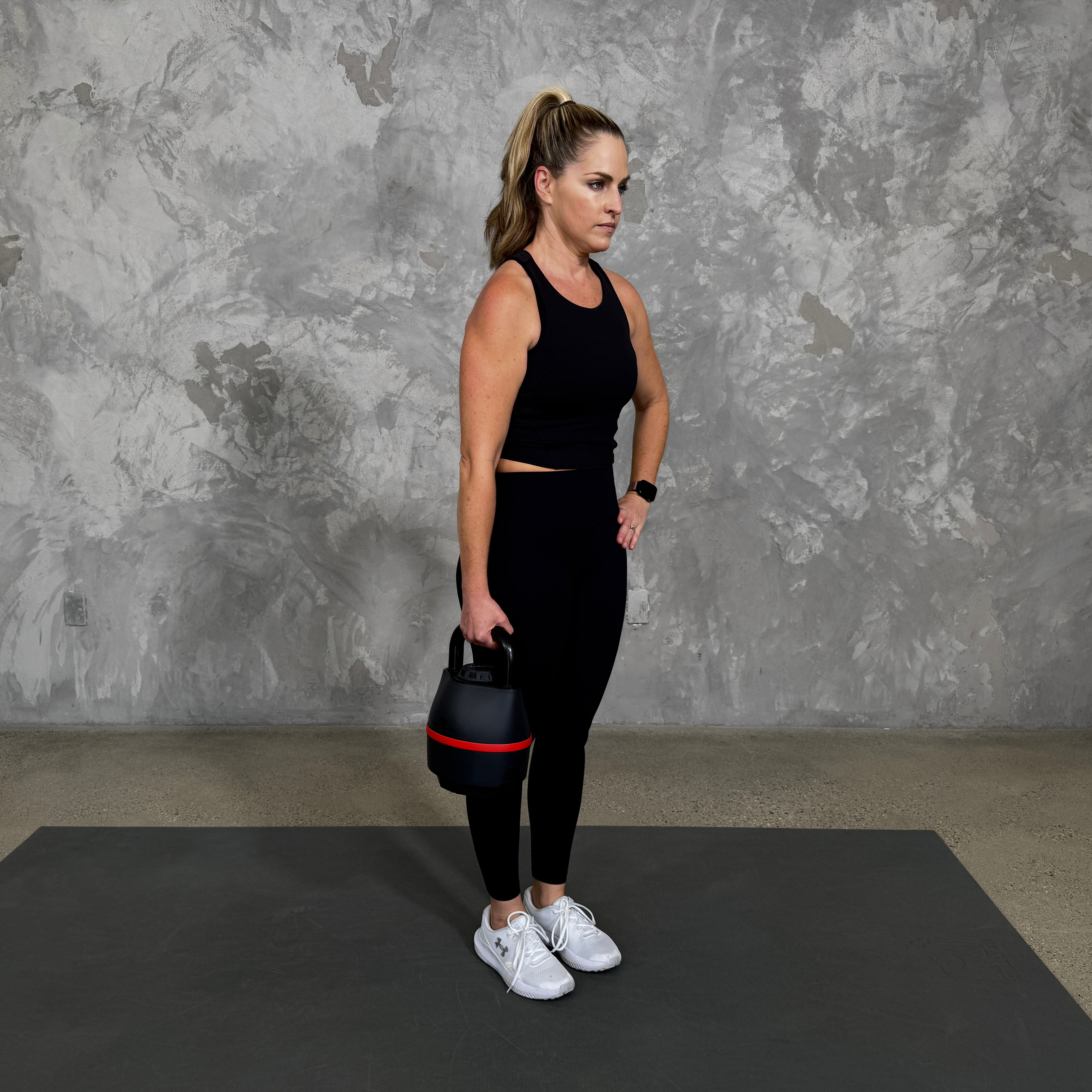 Woman in blue sportswear exercises with kettlebell
