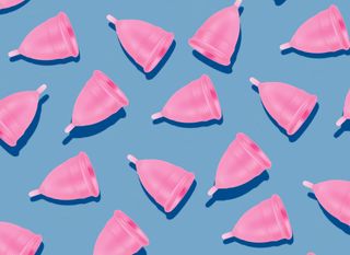 A blue background with multiple pink menstrual cups displayed.