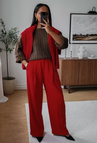 a woman wearing red trousers and a red cardigan with a brown sweater, which is one of the best colors that go with red