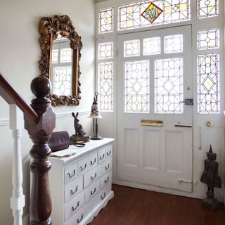 hallway with white coloured and wooden floor and mirror