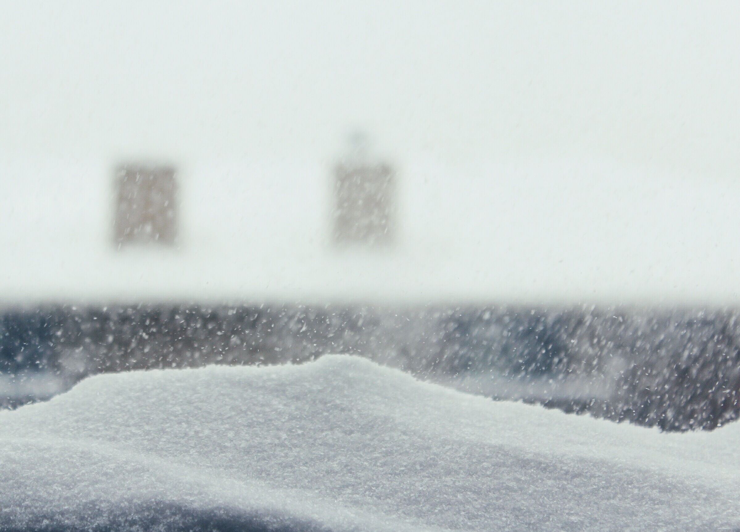 Blizzard Against Building Seen From Glass Window