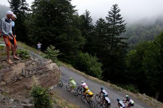 A fan looks at the pack riding in the 17th stage of the 2012 Tour de France cycling race starting in Bagneres-de-Luchon and finishing in Peyragudes