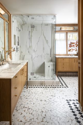 A bathroom with a marble wall and seating inside the shower area