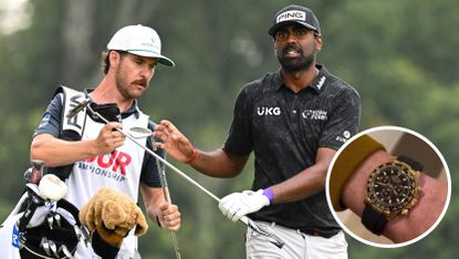 Sahith Theegala walks off the green and hands his club to his caddie