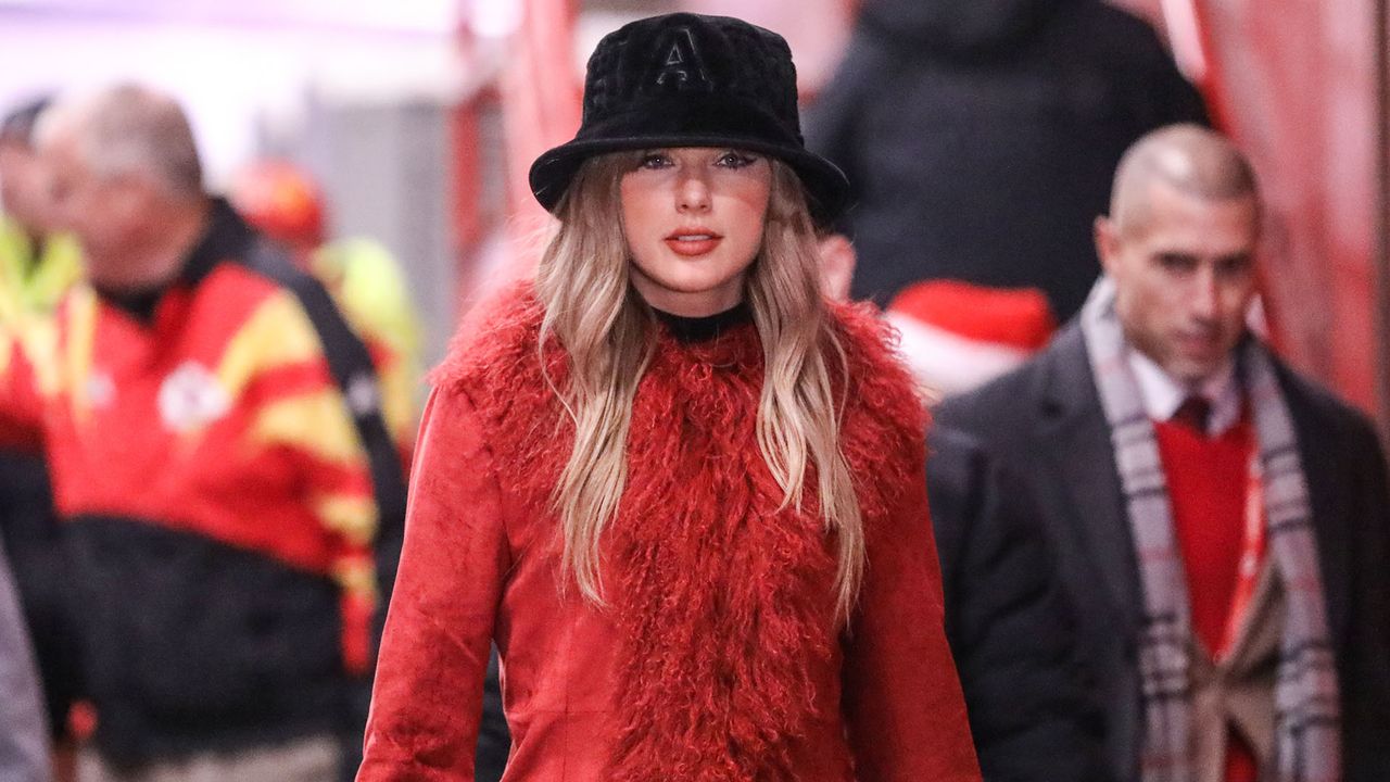 Taylor Swift wears a Crimson Fur Coat and Black Hat to a Kansas City Chiefs Game on December 21, 2024.