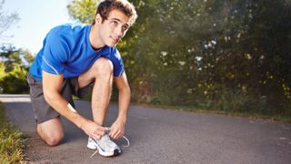Runner on road fastening loose shoelace