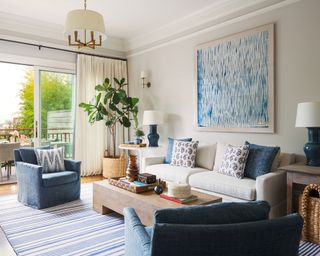 White living room with blue accents and art
