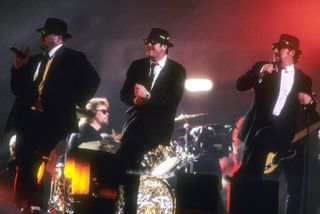 The Blues Brothers perform onstage at the Louisiana Superdome during the halftime show of Superbowl XXXI on January 26, 1997 in New Orleans, Louisiana. ( Pictured: John Goodman; Jim Belushi; Dan Akroyd)