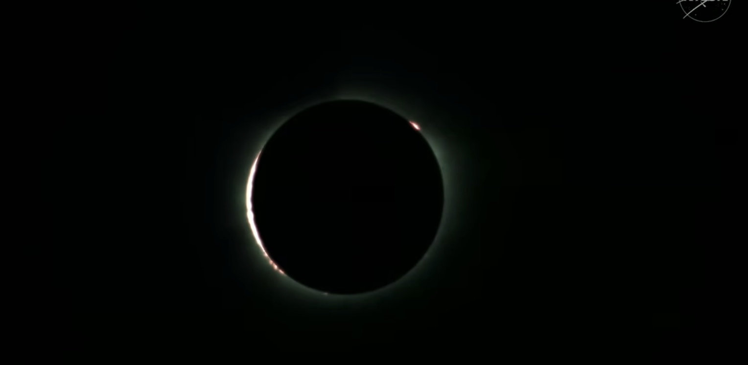 The sun glows behind the moon during a total solar eclipse