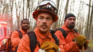 Kevin Alejandro as Manny with two men standing behind him. They're all resting their hands on shovels. 