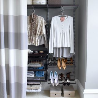Well-organised wardrobe with a curtain