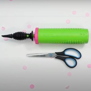 white background with scissors and balloon pump