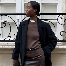 Woman in brown sweater and black coat