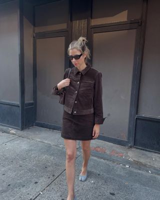 Robin Reetz in New York City wearing a brown corduroy miniskirt and matching jacket with Maison Margiela Tabi ballet heels.