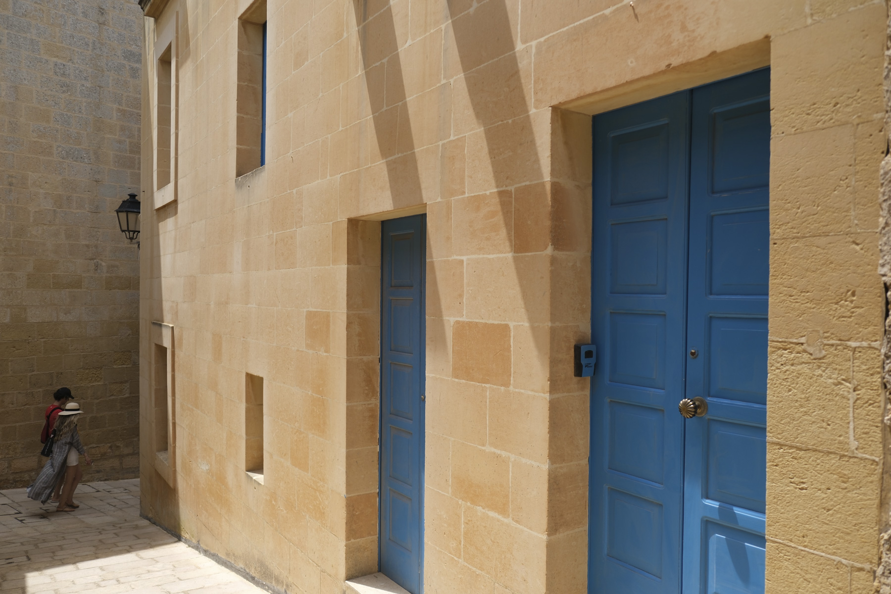 Vibrant blue doors and honey-coloured walls in ancient mediterranean town