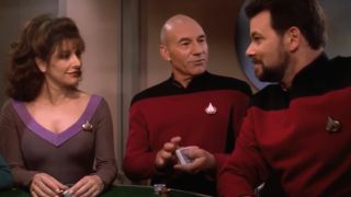 Patrick Stewart smiles while shuffling cards between Marina Sirtis and Jonathan Frakes in the Star Trek The Next Generation series finale.