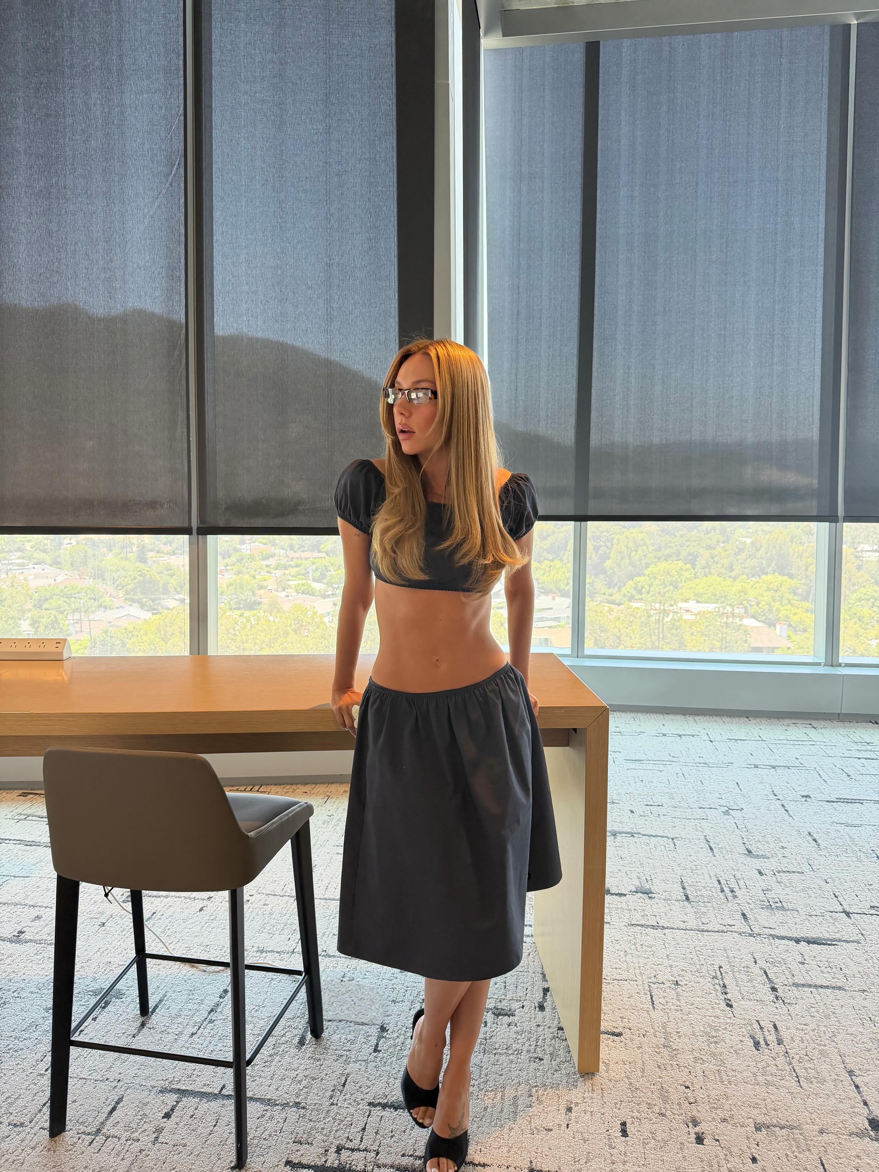 Spanish woman wearing a low-rise skirt, a summer 2026 trend.