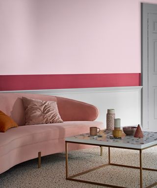 Tonal pinks used in creative color blocking paint ideas on wall, and terrazzo flooring and coffee table.