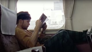 Pearl Jam member reading on a train