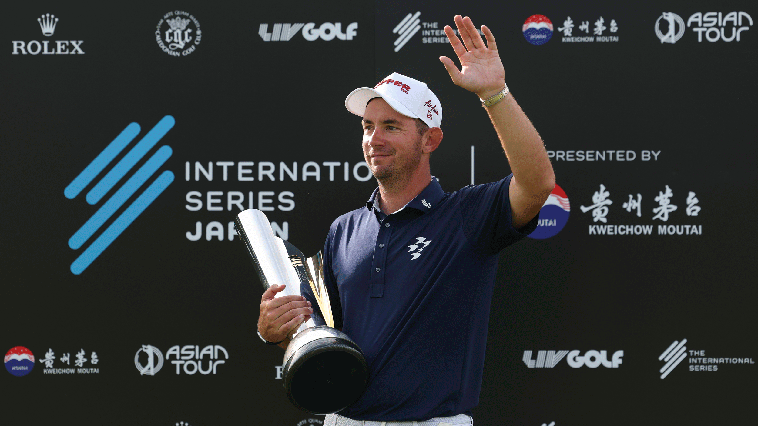 Lucas Herbert waves to fans while holding the International Series Japan trophy in 2025