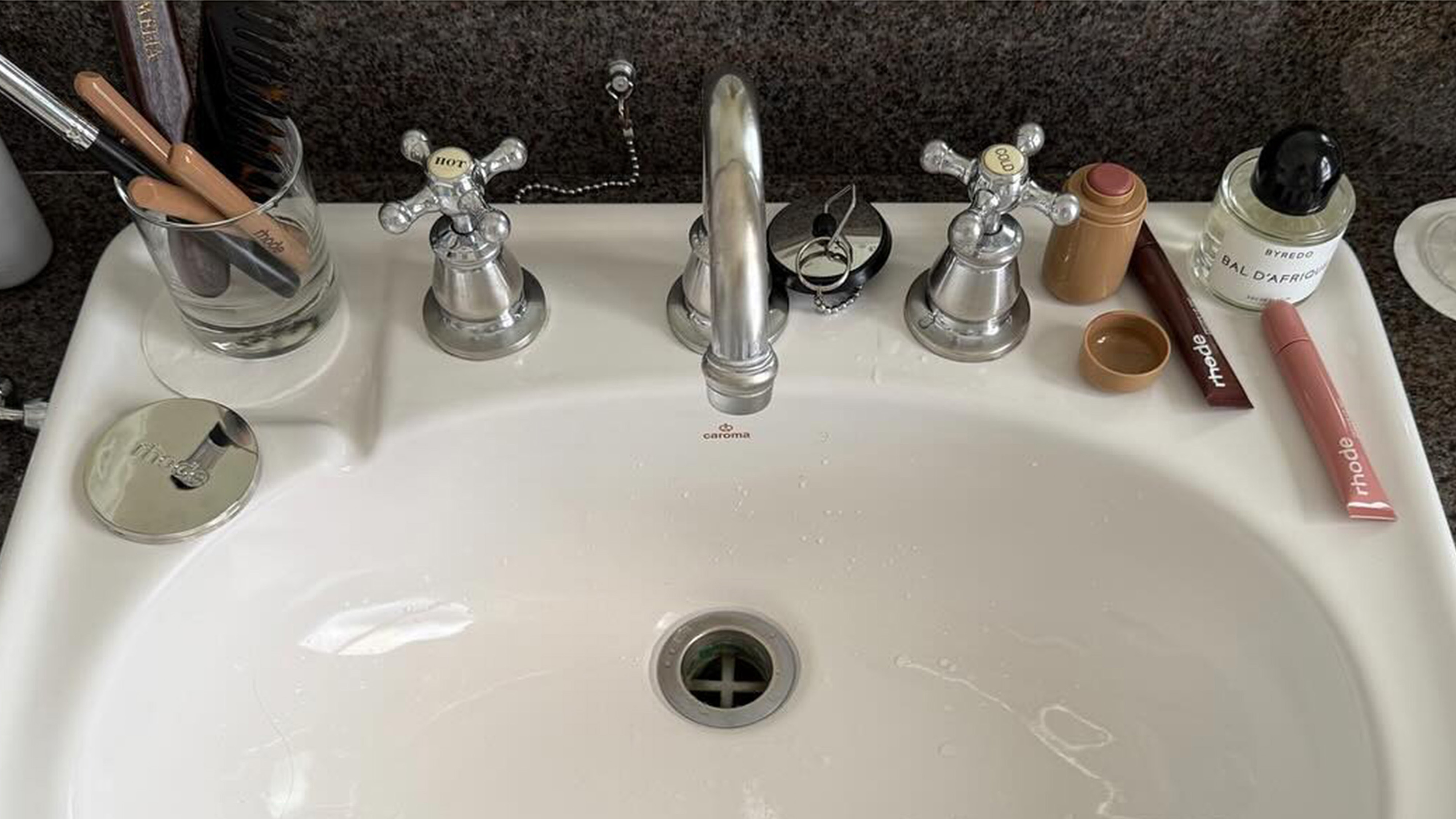 Bathroom sink filled with beauty products.