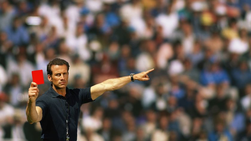 A football referee holding up a red card