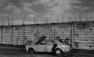 Black and white image of an abandoned car