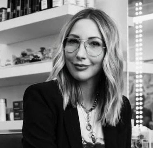 a black and white headshot of a white woman with glasses