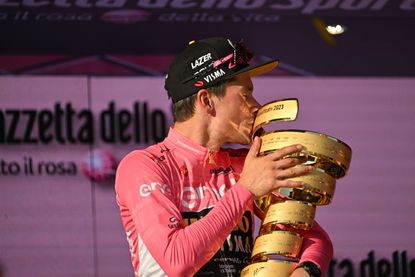 Primoz Roglic kissing the Giro d'Italia trophy. Who will reach the top step of the podium at Giro d'Italia 2024. 