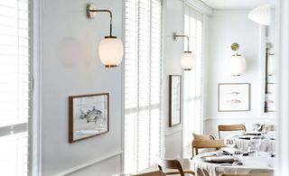 Old fashion light fixtures line the walls with geometric picture frames below