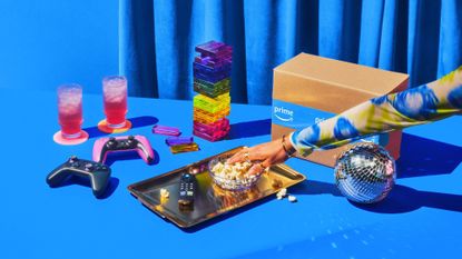 A woman's hand reaching for a bowl of popcorn, surrounded by various products and an Amazon Prime Day deals box.