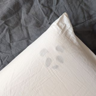 The Panda Memory Foam Bamboo pillow being tested on a grey linen duvet cover