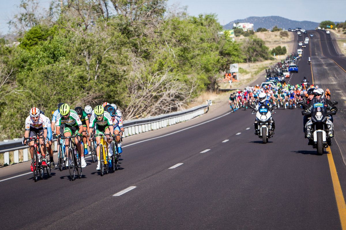 A mens group goes up the road at the start of the stage