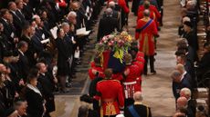 The coffin of Queen Elizabeth II with the Imperial State Crown resting on top is carried by the Bearer Party into Westminster Abbey