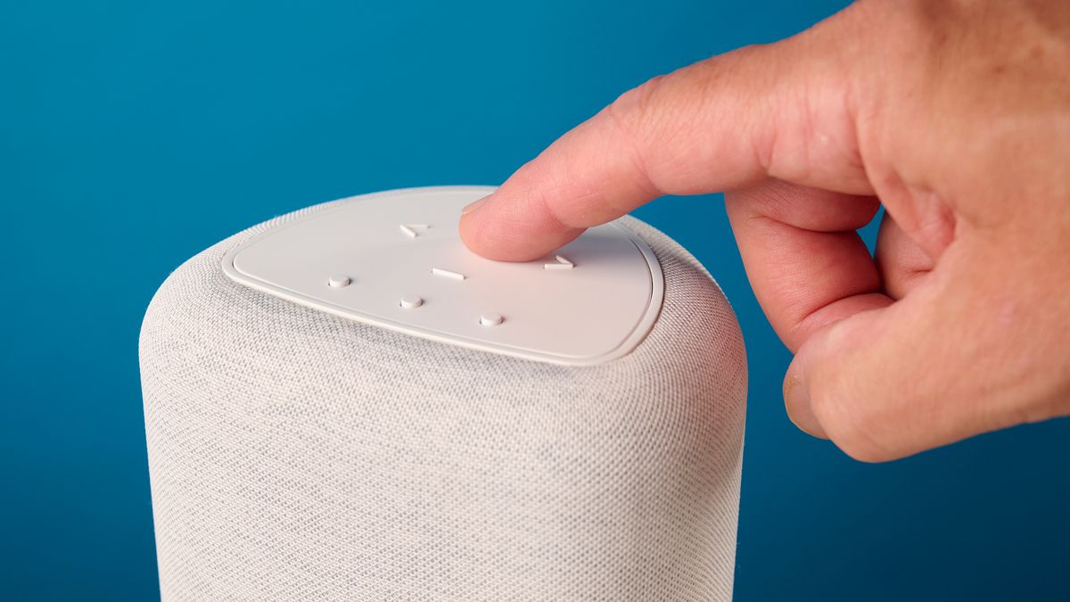 the bluesound pulse flex wi-fi speaker in pale gray photographed against the blue tom's guide background
