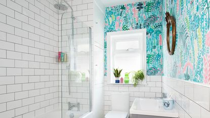 bathroom with pastel floral wallpaper and white tiles