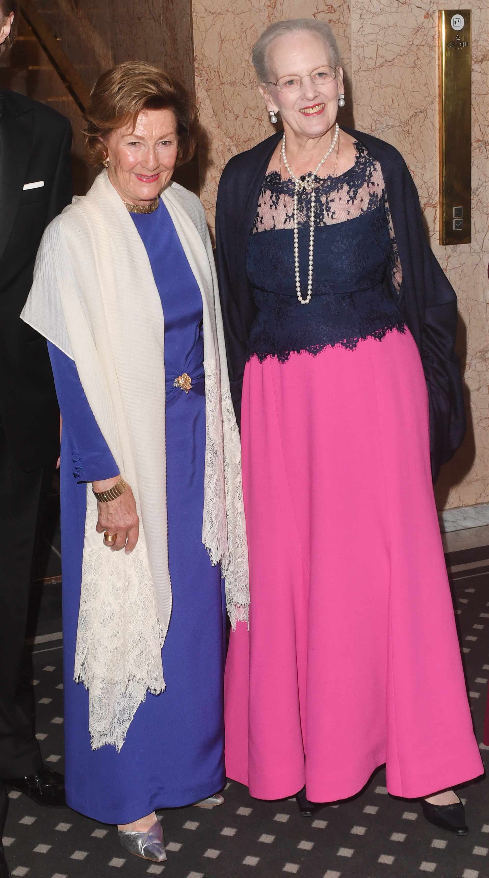 Queen Sonja and Queen Margrethe of Norway posing next to each other in evening dresses