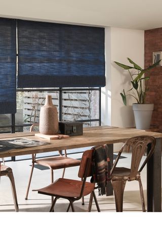 Blinds in dining room with dining table, by Luxaflex