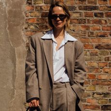 woman wearing blazer,button-down shirt, and trousers