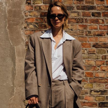 woman wearing blazer,button-down shirt, and trousers 