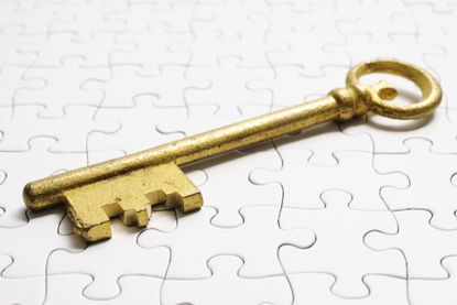 gold antique skeleton key on white puzzle