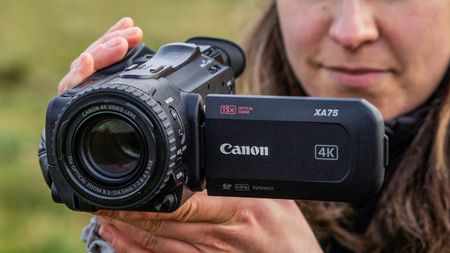 Woman using a Canon XA75 camcorder outdoors