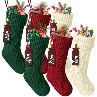 Two green, two red, and two cream knitted stockings full of presents with black nametags and white italic writing: John, Alan, Peter, Tom (left to right)