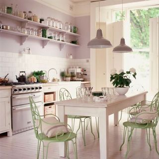 Kitchen with white walls and white shelves with dining table