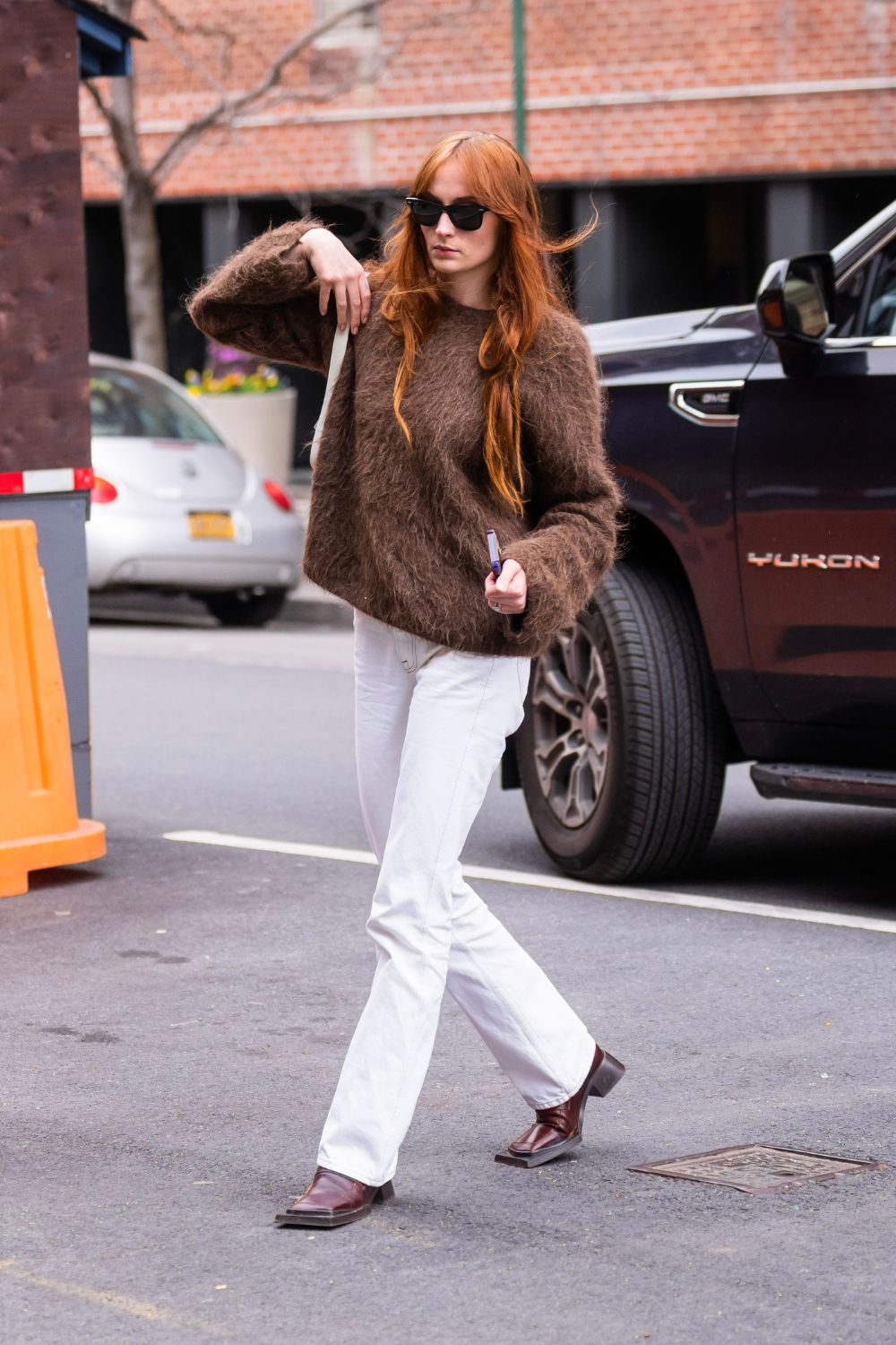 Sophie Turner wearing brown toteme jumper and white jeans in NYC