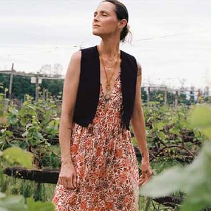 Woman wearing a dress and waistcoat in a field