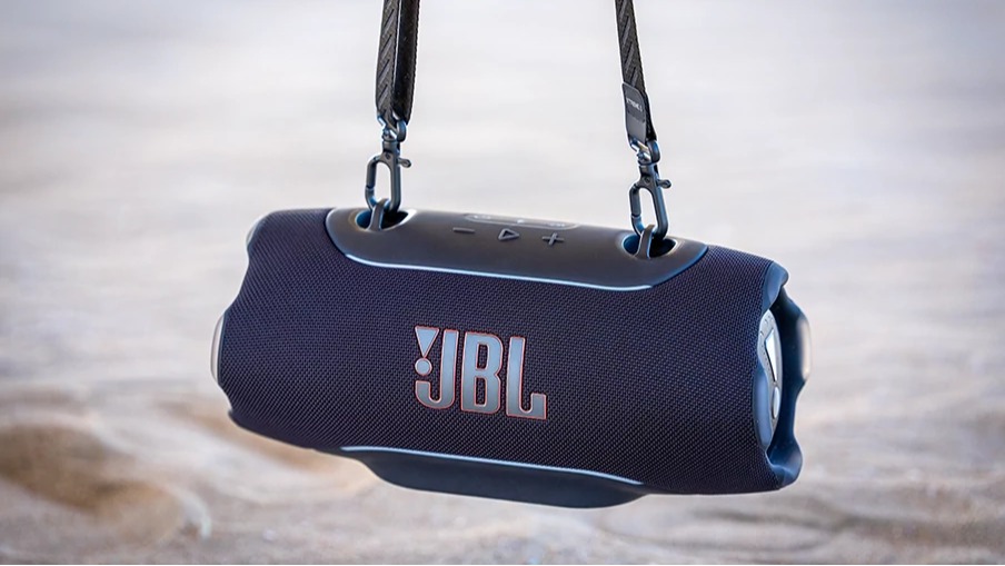 JBL Xtreme 5 Bluetooth speaker in navy blue hanging from its strap