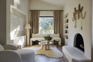 living room filled with vintage furniture, organic shaped rug, wavy bench seat and fireplace