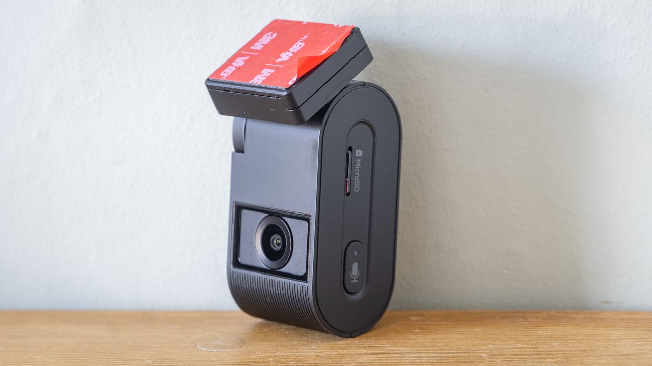 Viofo VS1 dashcam on a wooden table in front of a white wall