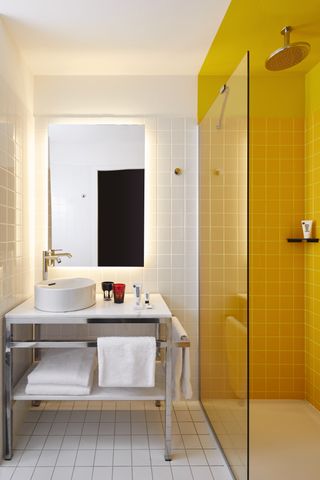 A small bathroom with half the space painted yellow